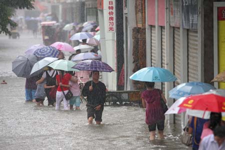 (080723) -- XIANGFAN, July 23, 2008 (Xinhua) -- Pedestrians wade on a flooded road in Xiangfan City, central China's Hubei Province, July 22, 2008. A heavy rain hit the city Tuesday causing some roads flooded. The local PLA soldiers and officers have thrown themselves into the fight against the floods.   (Xinhua/Yu Xiang)  (ly/wcy)